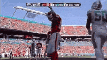 a football game is being played in a stadium with a scoreboard showing the score of the game