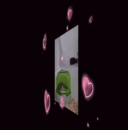 a hamster is sitting in a green corner of a cage with pink hearts around it .