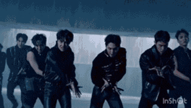 a group of men are dancing in a dark room with the words inshot at the bottom