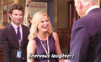 a woman in a purple dress is laughing while talking to a man in a suit
