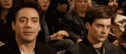 two men are sitting in front of a crowd of people .