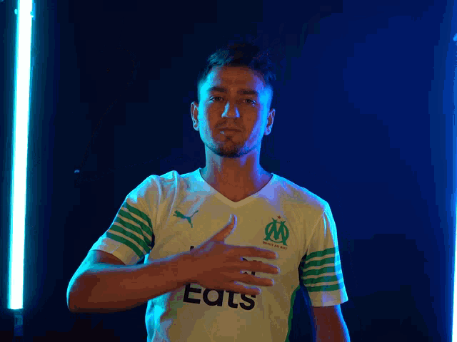 a man wearing a white and green shirt that says eats