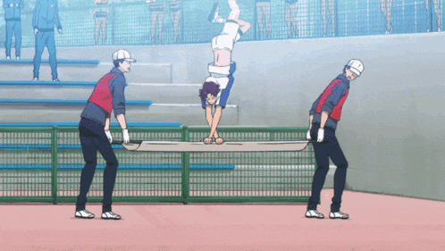 a man is doing a handstand in a stadium while two men carry him