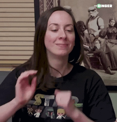 a woman wearing a black shirt with a picture of darth vader in the background .