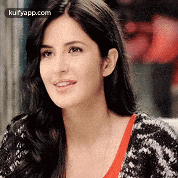 a close up of a woman 's face with long hair wearing a black and white sweater .
