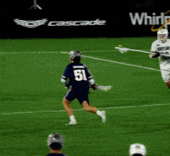a lacrosse game is being played in front of a progressive sign