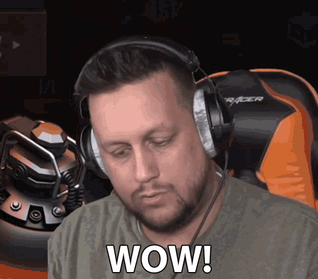 a man wearing headphones says wow in front of a racer chair