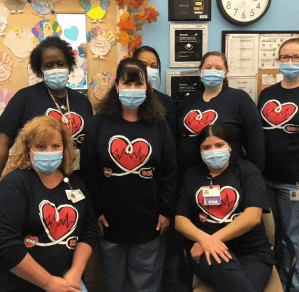 a group of nurses wearing face masks and shirts with hearts on them are posing for a photo