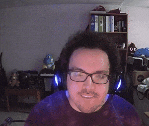 a man wearing glasses and headphones is smiling in front of a shelf with binders on it