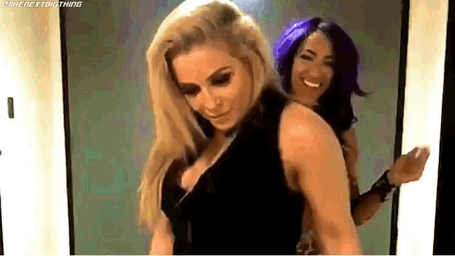 a couple of women are standing next to each other in a room .