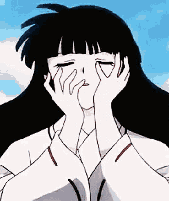 a girl is covering her face with her hands .