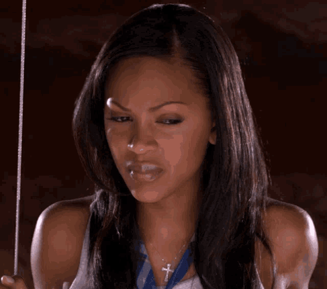 a woman with a cross necklace is making a face