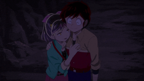 a boy and a girl standing next to each other in the dark