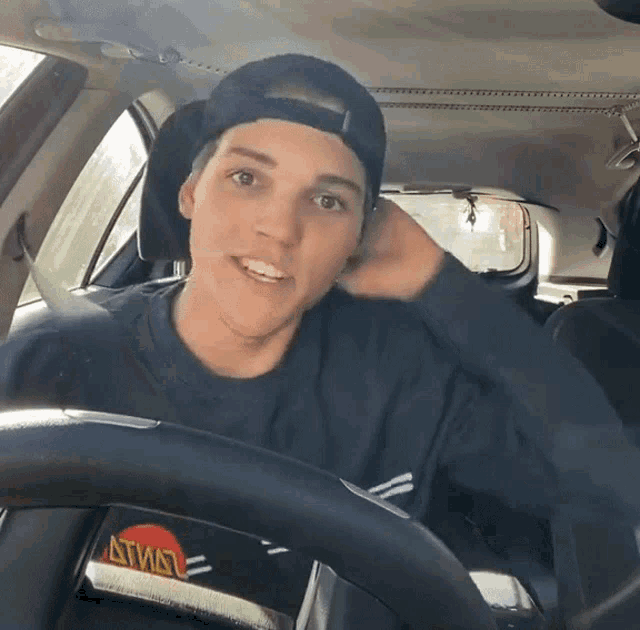 a man sitting in a car with a steering wheel that says atm