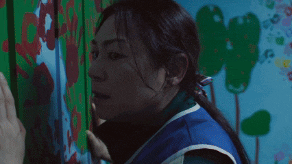a close up of a woman 's face in front of a mural