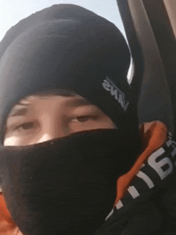 a person wearing a black beanie and a black mask with the word nm2 on it