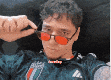 a man wearing sunglasses and a jersey with the word aljati on it