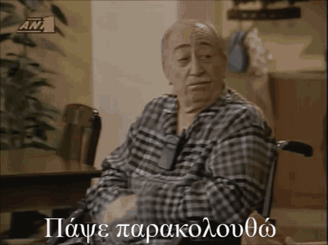 a man in a plaid shirt is sitting in a wheelchair with the words " pawe parakolovoa " written below him