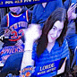 a woman in a blue shirt is sitting in front of a group of people wearing blue jerseys .