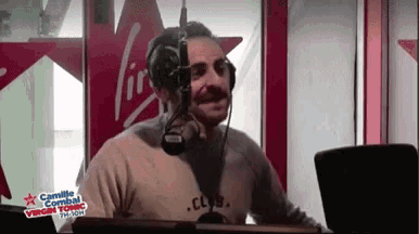a man is wearing headphones in front of a virgin radio station