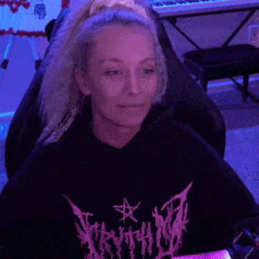 a woman wearing a black sweatshirt with a pink star on the front
