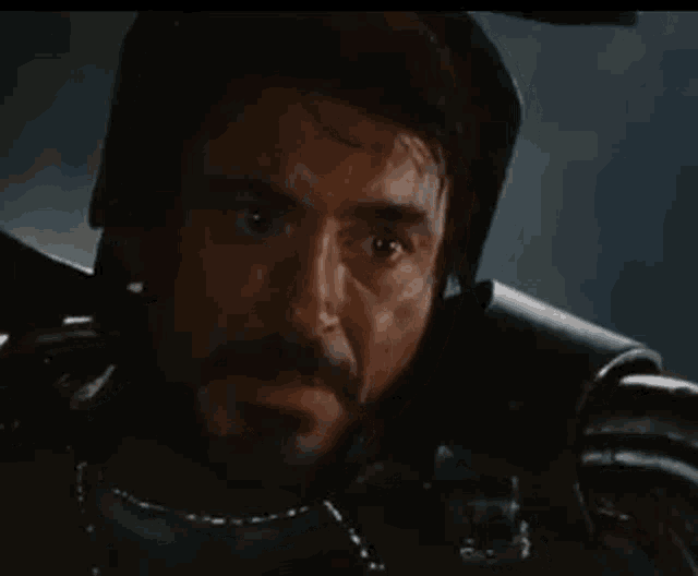 a man with a beard is wearing a helmet and looking at the camera .