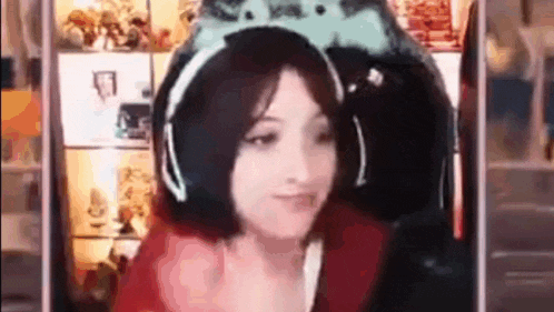 a woman wearing headphones and a headband is sitting in front of a computer screen .