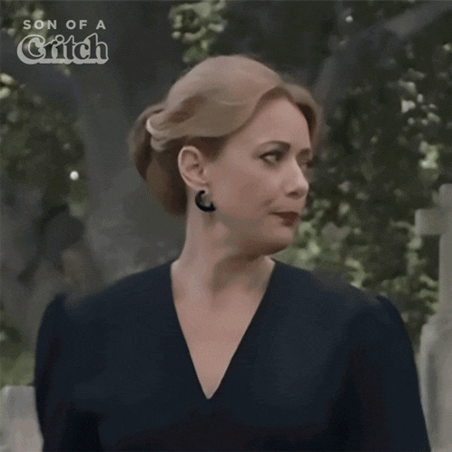 a woman is standing in front of a cemetery and saying fine