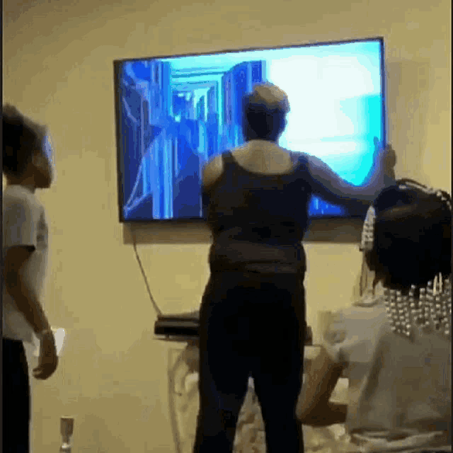 a group of people are playing a video game on a flat screen television .