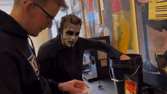 a man wearing a mask is looking at a bag of espresso