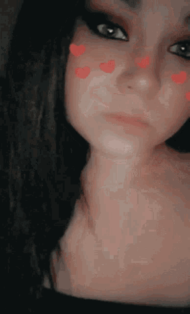 a close up of a woman 's face with hearts on it