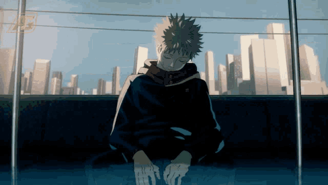 a person in a black jacket is sitting in front of a city skyline