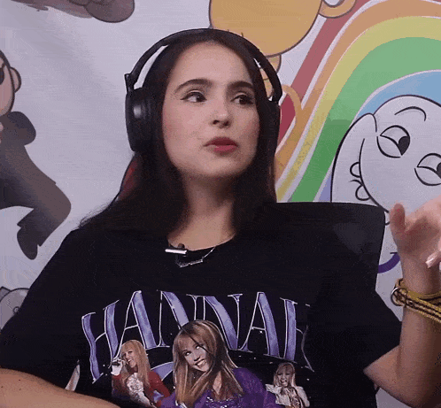 a woman wearing headphones is wearing a hannah montana t-shirt