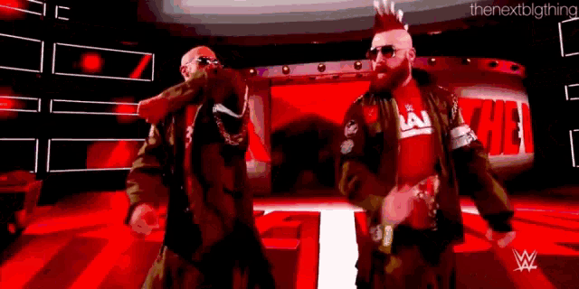 two men are standing next to each other on a red stage .