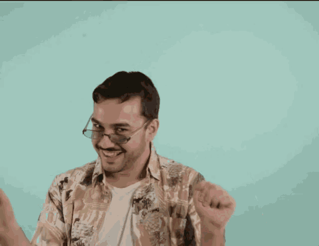 a man wearing glasses and a shirt is dancing in front of a blue background