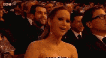 a woman in a strapless dress is sitting in a crowd of people with bbc on the bottom right corner