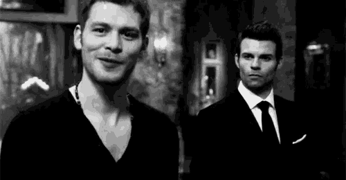 two men in suits are standing next to each other in a room .