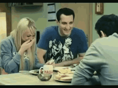 a group of people are sitting at a table with a mug that says " mali " on it