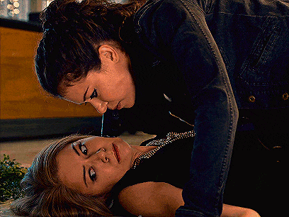 a woman in a denim jacket is laying on the floor with another woman