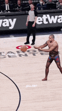 a man without a shirt is holding a basketball on a basketball court in front of a sign that says way network