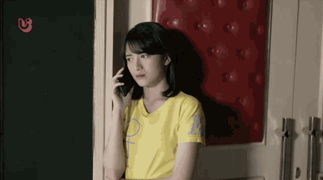 a woman in a yellow shirt is talking on her phone