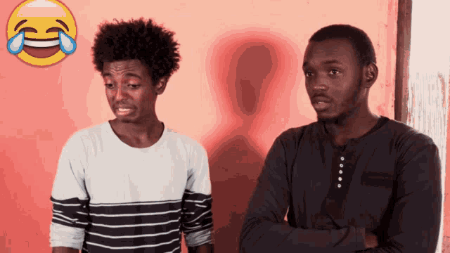 two men standing next to each other with a crying emoji in the background