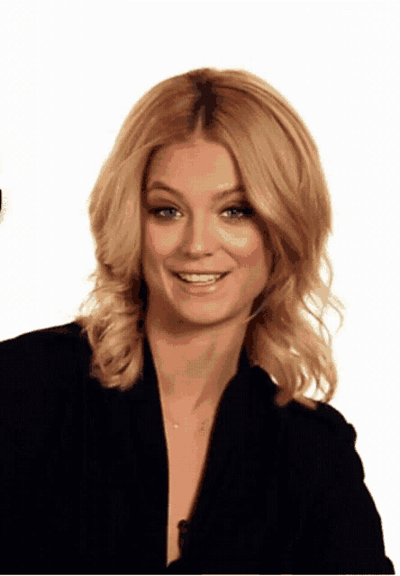 a woman with blonde hair and blue eyes is smiling