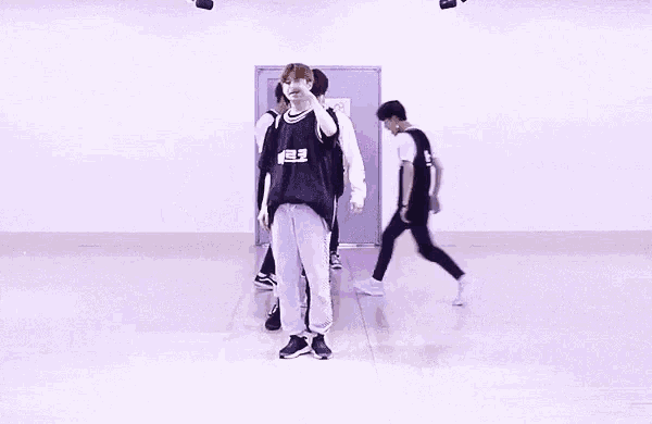 a group of young men are doing a dance in a room .