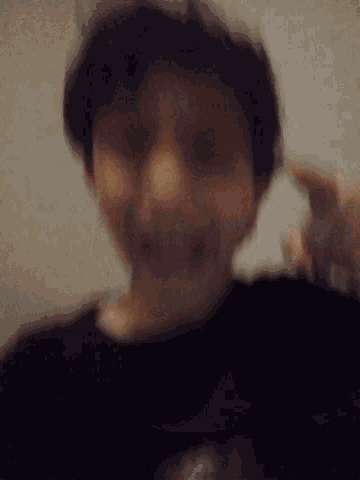 a blurry picture of a person 's face with their hands outstretched