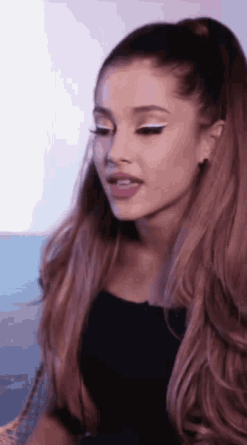 a woman with long hair is wearing a black top