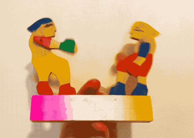 a person is holding a toy that looks like a boxer