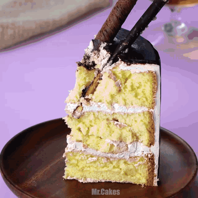 a slice of cake sits on a wooden plate with the words mr.cakes on the bottom