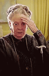 a woman is holding her hand to her forehead while wearing a cane .
