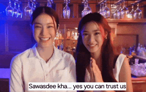 two women are standing next to each other in front of a bar and smiling .